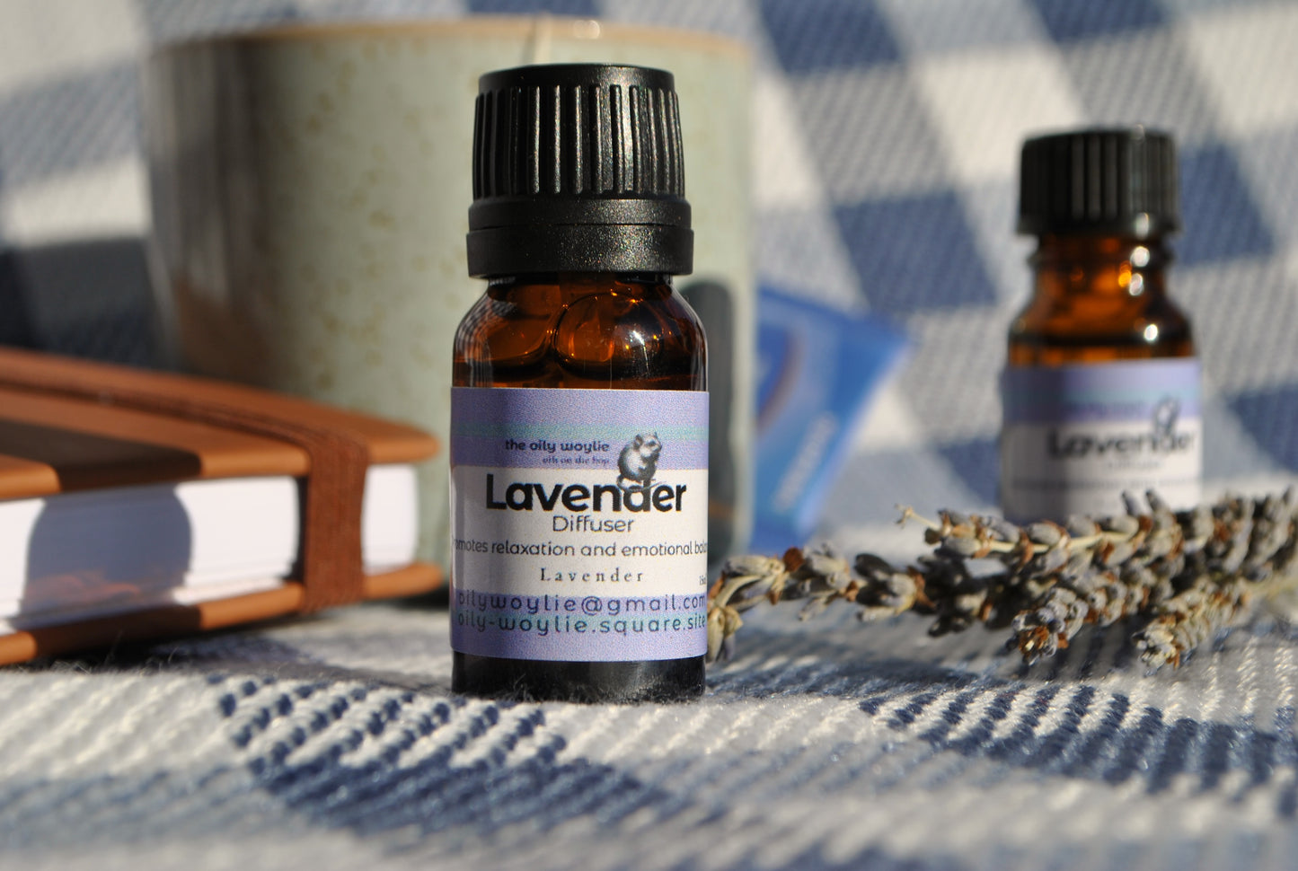 Two bottles of lavender essential oil on a checkered fabric background