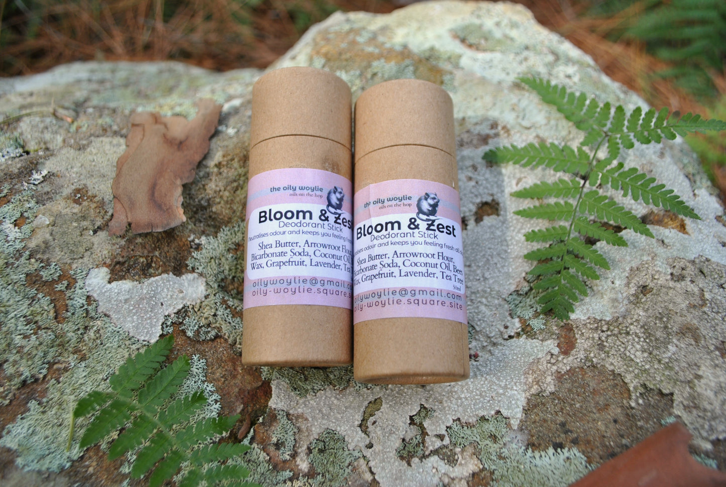 Two cardboard rolls with 'Bloom & Zest' branding on a natural stone surface with greenery.