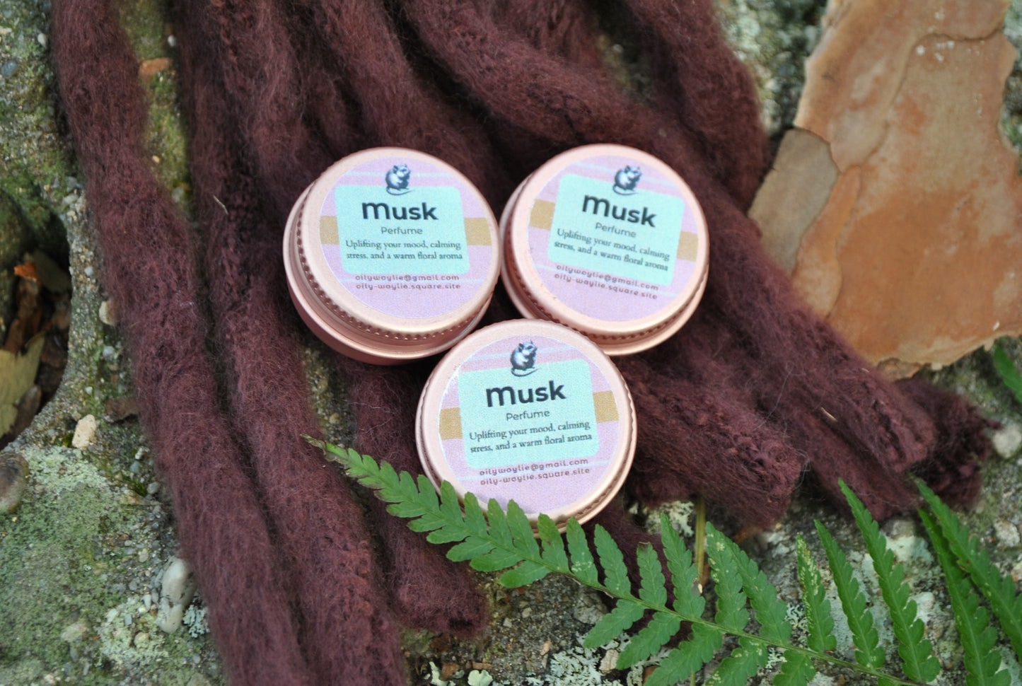 Three containers labeled 'Musk' on a natural background with leaves and fabric.
