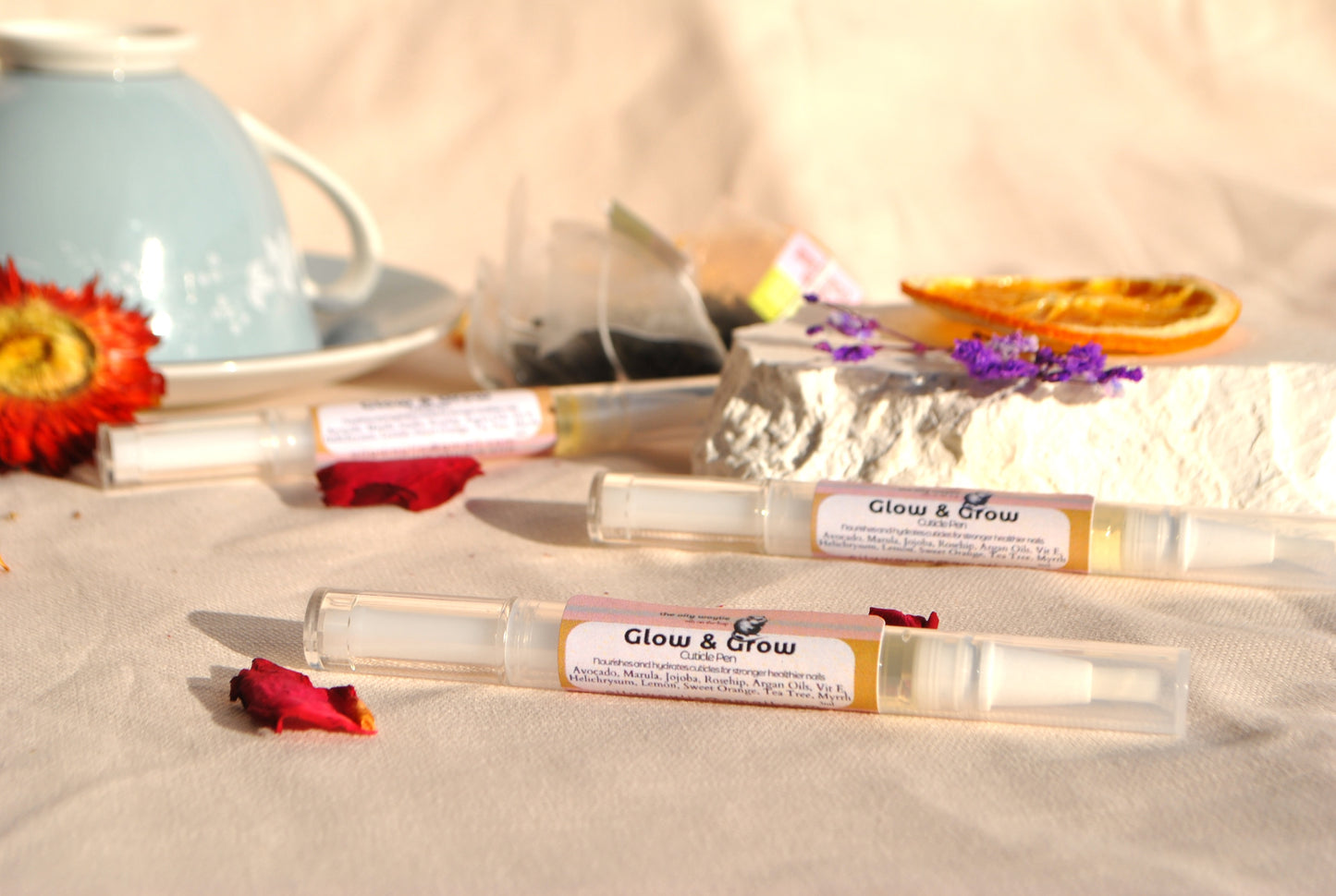 Glow & Grow lip balm tubes on a textured surface with decorative elements.