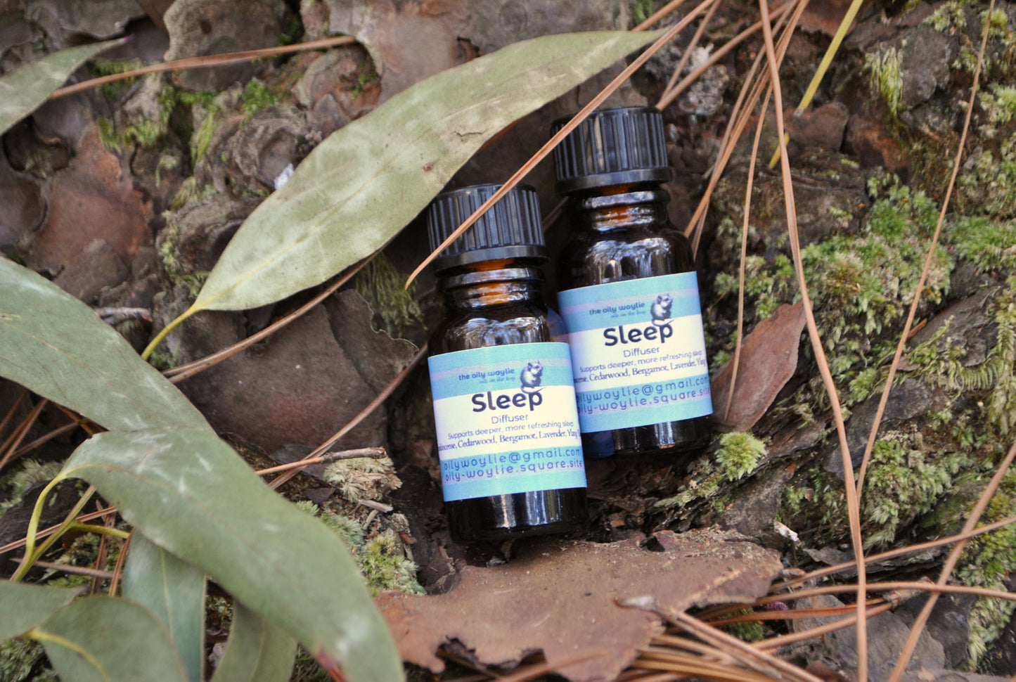 Two bottles labeled 'Sleep' on a natural background with leaves and moss.