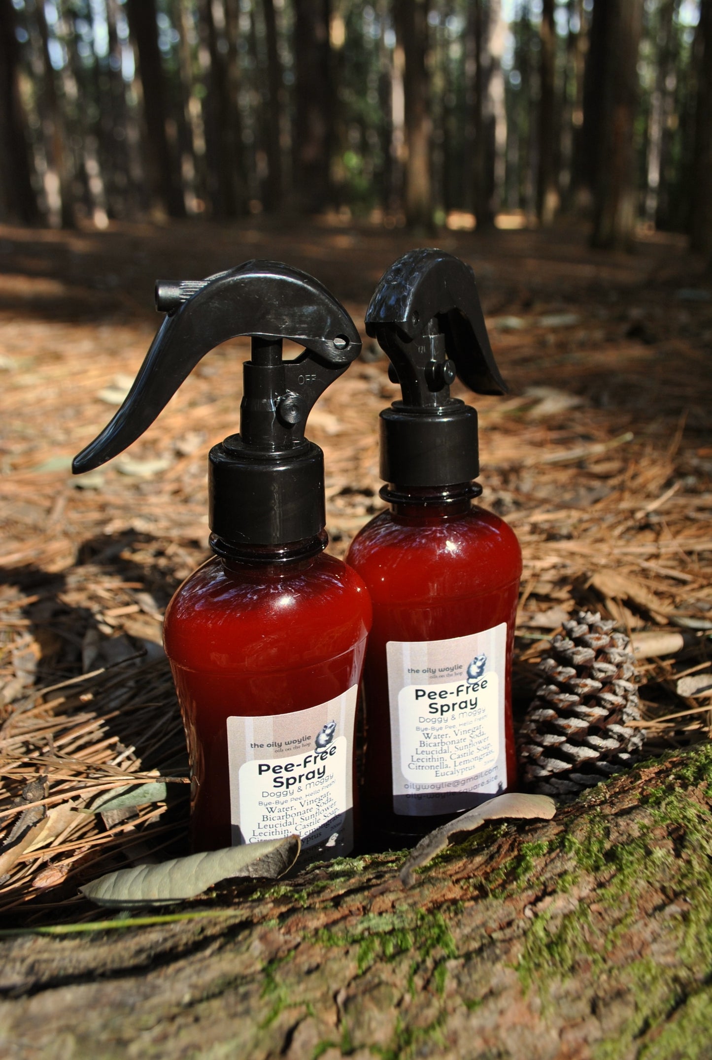 Two bottles of Pee-free Sprays on a log with a forest background