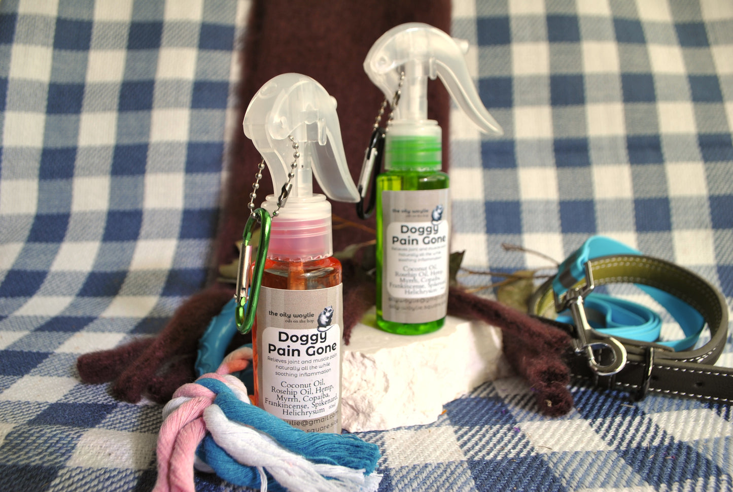 Two bottles of 'Doggie Pain Gone' on a checkered fabric background