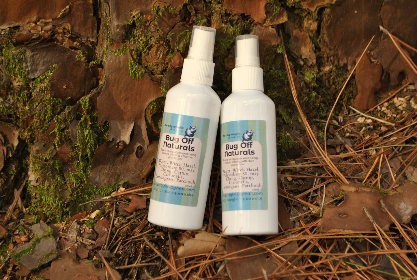 Two bottles of 'Bug Off Naturals' on a natural background with leaves and wood.