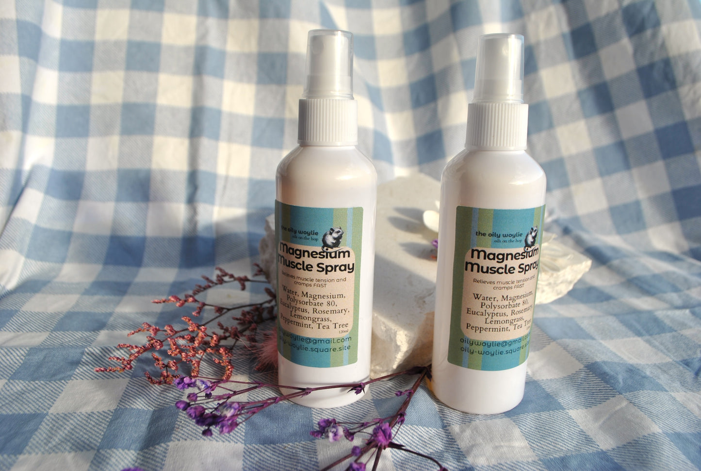 Two bottles of magnesium muscle spray on a checkered fabric background