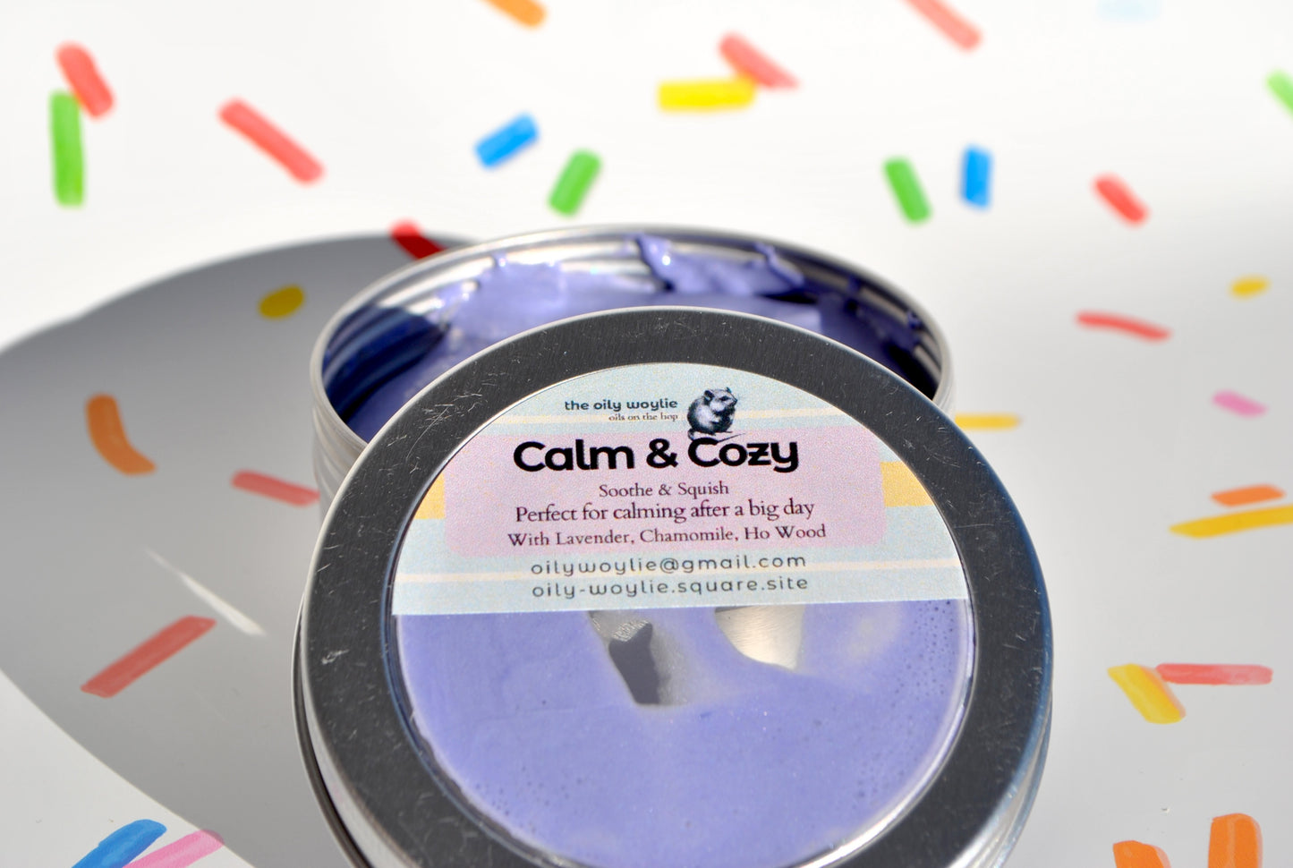 Calm & Cozy product in a silver container with colorful sprinkles in the background