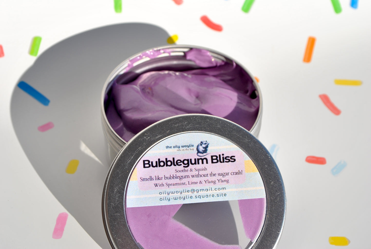Purple candy in a tin labeled 'Bubblegum Bliss' with colorful sprinkles in the background