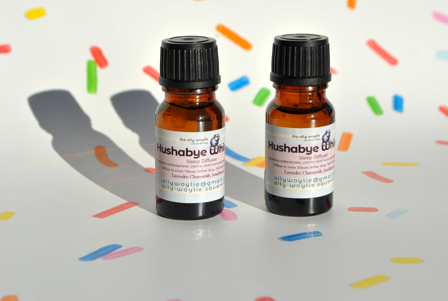Two small brown bottles labeled 'Hushabye' on a colorful background