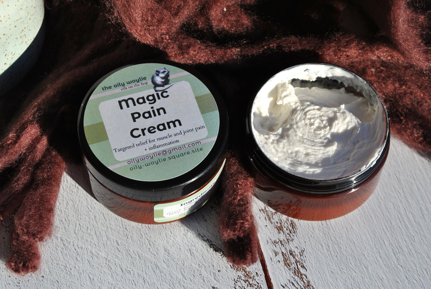 Jar of 'Magic Pain Cream' with a visible label on a textured surface.
