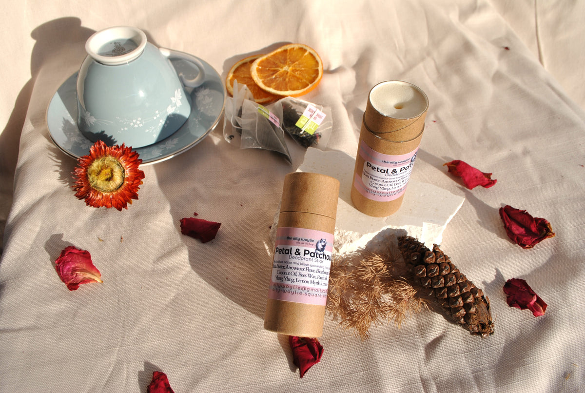 Deodorant stick Petal & Patchouli bottle, natural floral deodorant on a textured surface with flowers and a teacup. Opened
