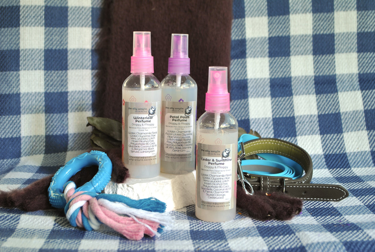 Trio of Doggy Perfume natural spray to keep dogs smelling freshon a checkered fabric background
