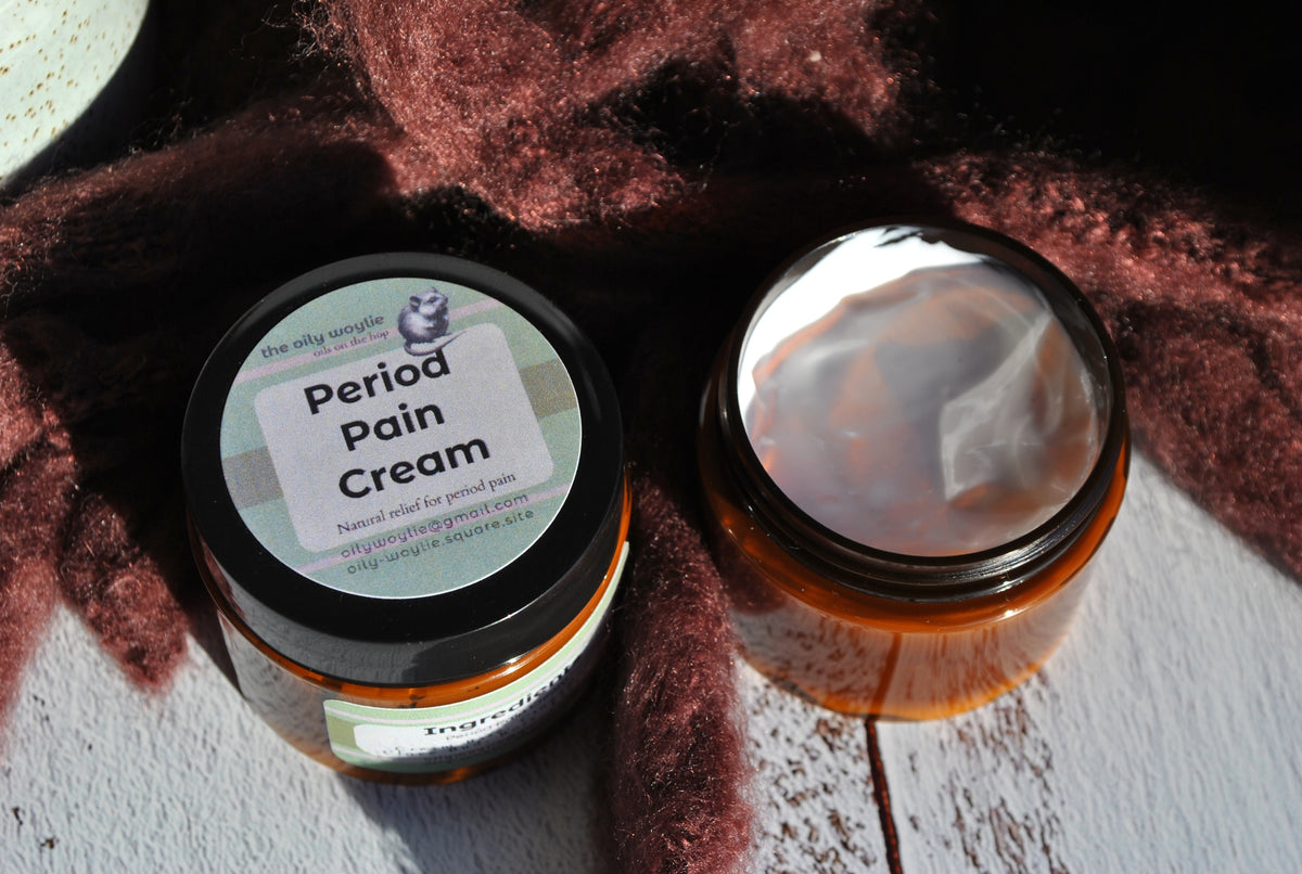 Period Pain Cream in jar, natural soothing cream for menstrual cramps and discomfort jar with lid removed on a textured surface