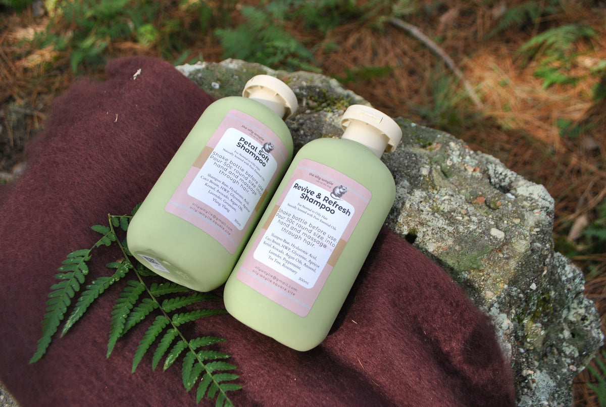 Revive & Refresh and Petal Soft natural shampoo bottles side by side, eco-friendly hair care on a brown fabric background
