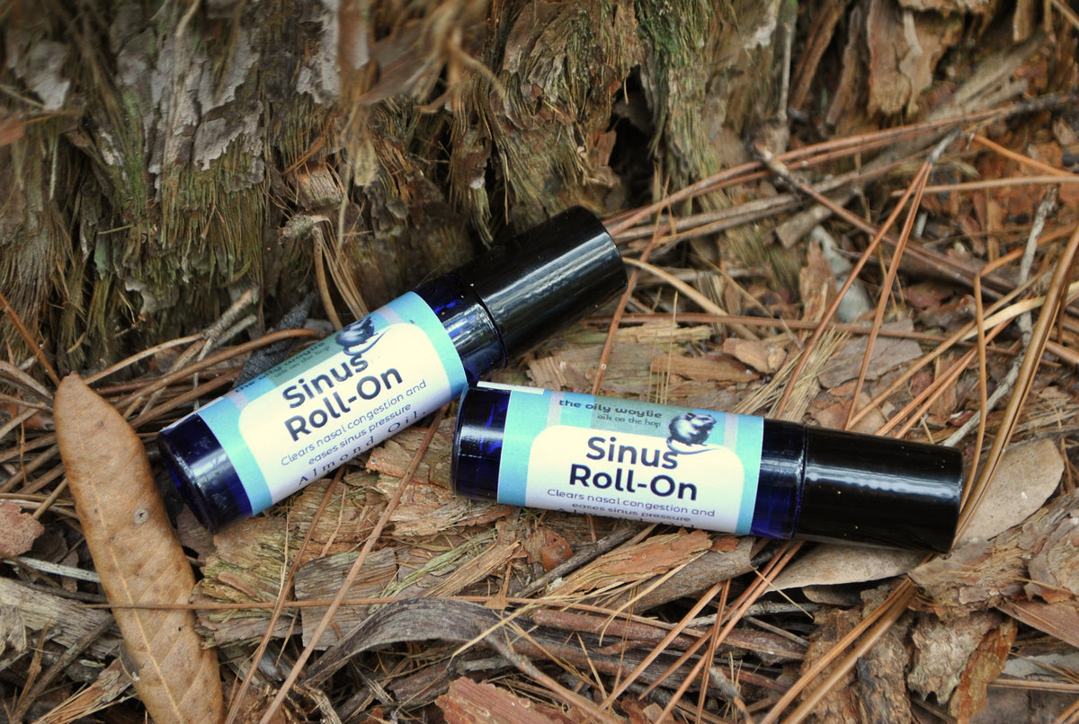 Sinus Roll essential oil roller blend, natural support for sinus relief on a natural background with leaves and wood.