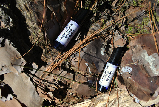 Two rollerball bottles labeled 'Black Cohosh' on a natural stone surface.