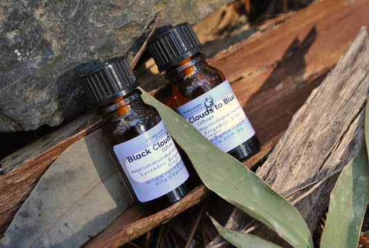 Two small brown bottles with labels on a wooden surface with leaves.