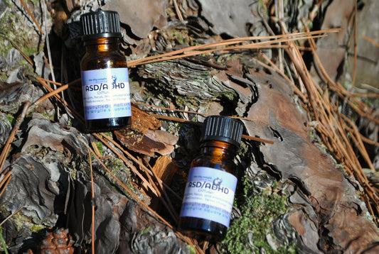 Two bottles labeled 'ASD/ADHD' on a natural background with wood and leaves.