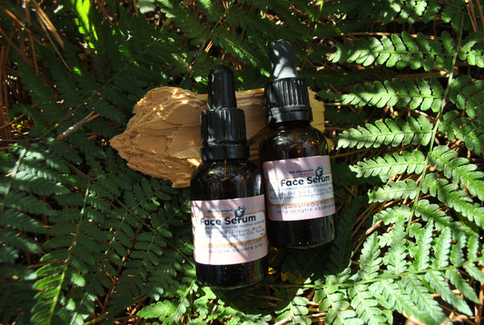 Two bottles of face serum on a leafy background