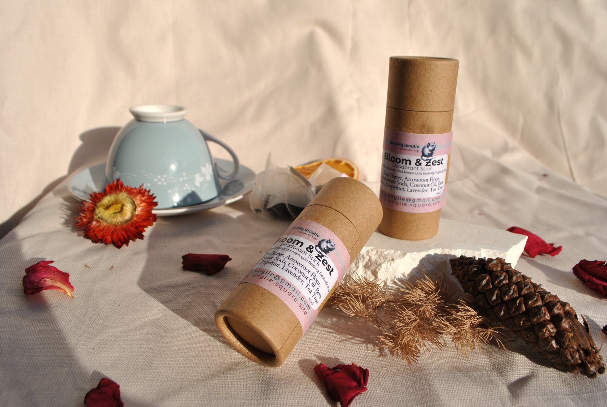 Two cardboard tubes with labels on a table with flowers and a teacup.