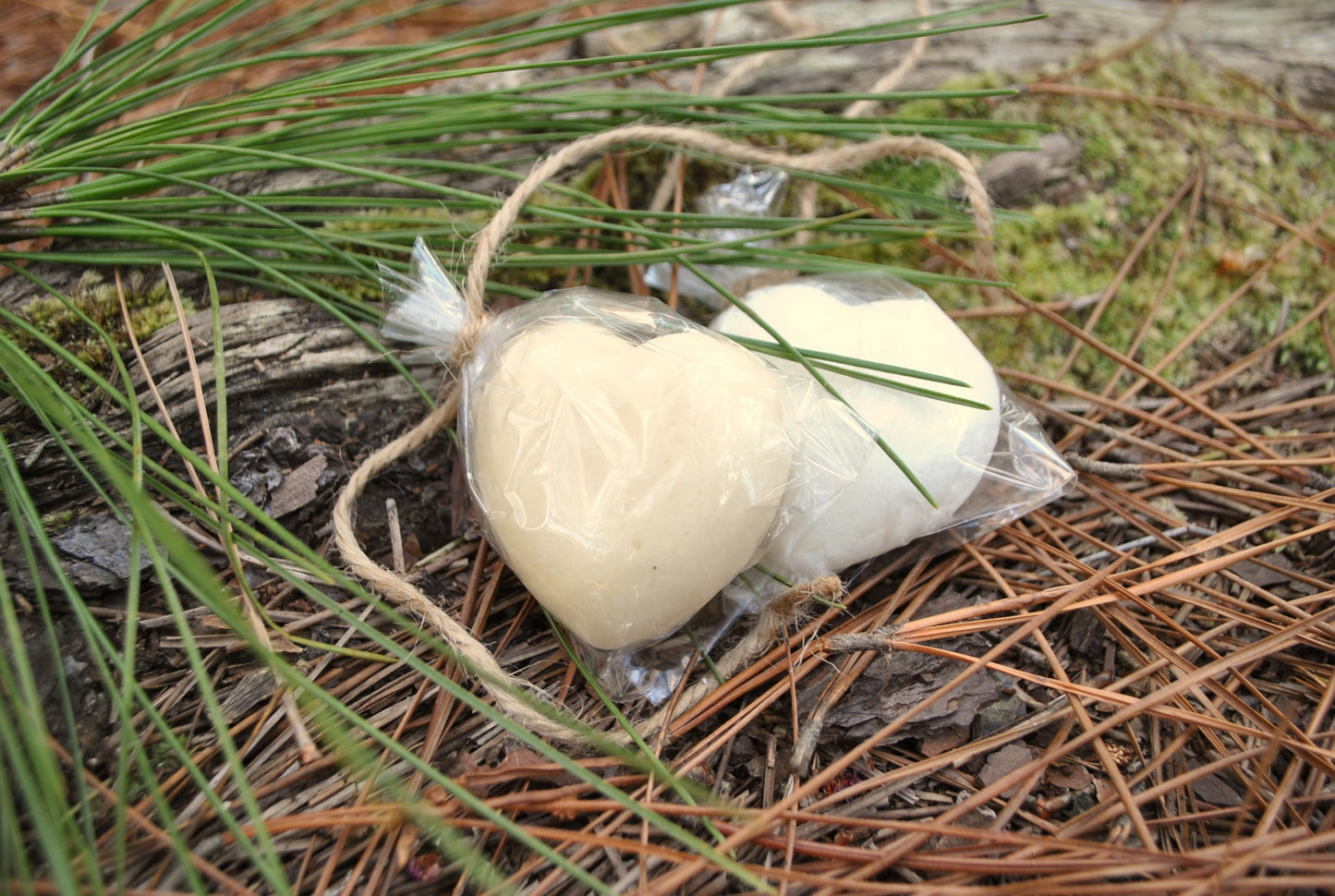 two bath melts surrounded by pine needles