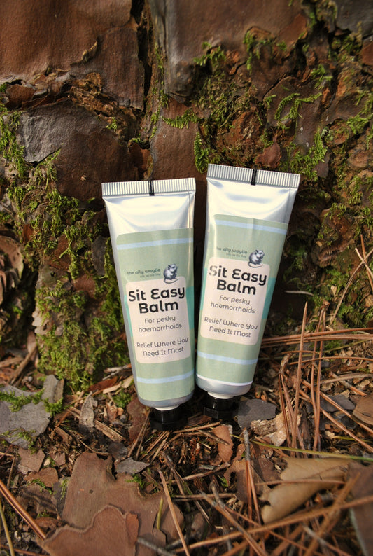 Two tubes of 'Sit Easy Balm' on a textured, natural background
