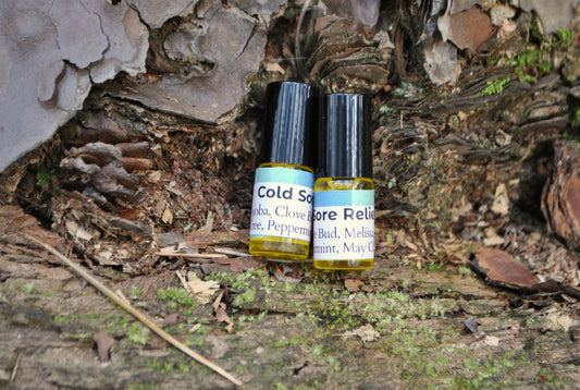 Two small bottles labeled 'Cold Sore Relief' and 'Aloe Relief' on a wooden surface with natural background.