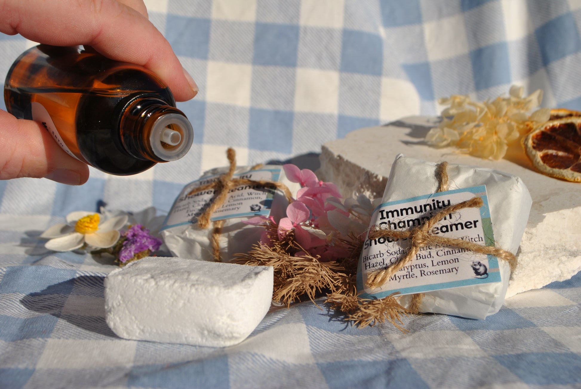 Hand holding a bottle over a bag labeled 'Immunity' on a checkered tablecloth.