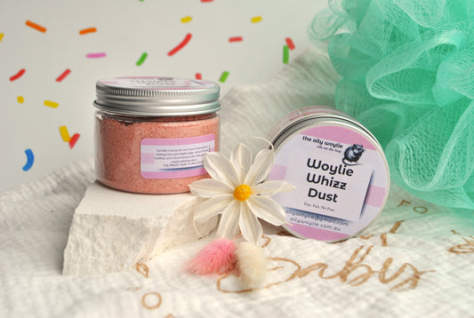 Two containers labeled 'Woylie Whizz Dust' on a textured surface with colorful confetti in the background.