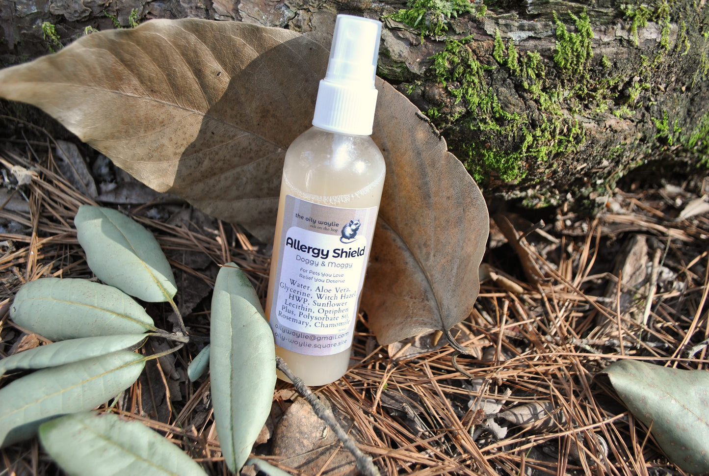 Allergy Shield spray bottle, natural spray to support pet parents with allergies to pet fur on a natural background with leaves and wood.