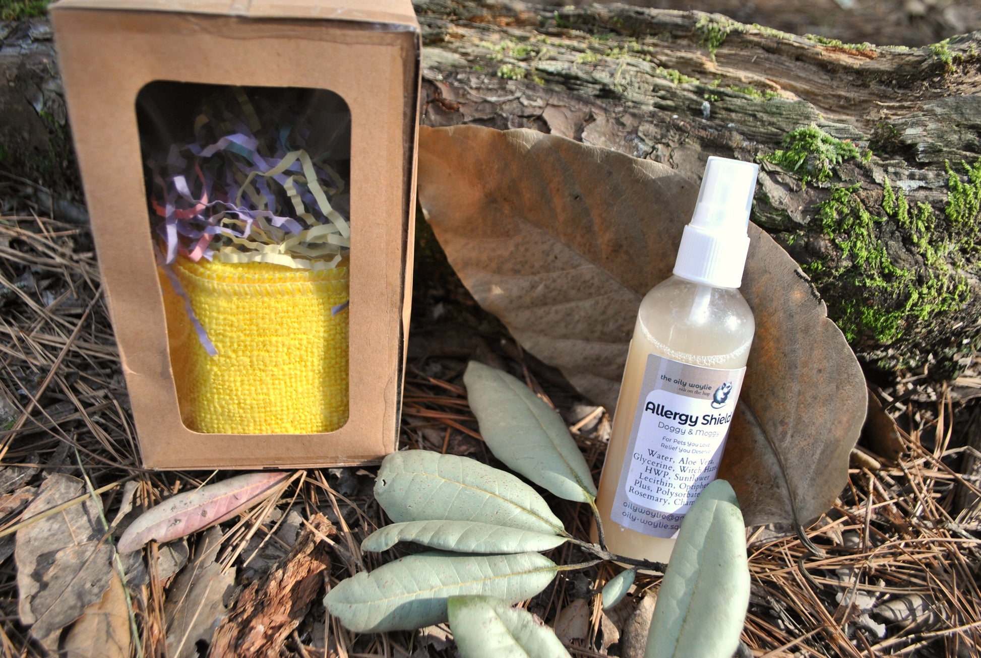 Allergy Shield spray bottle, natural spray to support pet parents with allergies to pet fur on a leaf with a small fire pit and yellow fabric in the background.