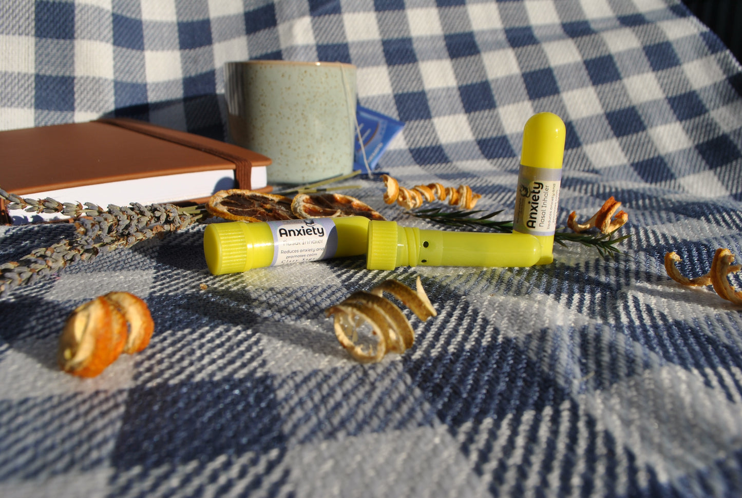 Anxiety Inhaler tube, natural essential oil aromatherapy for calm and relaxation Two yellow sticks on a checkered fabric background lid off