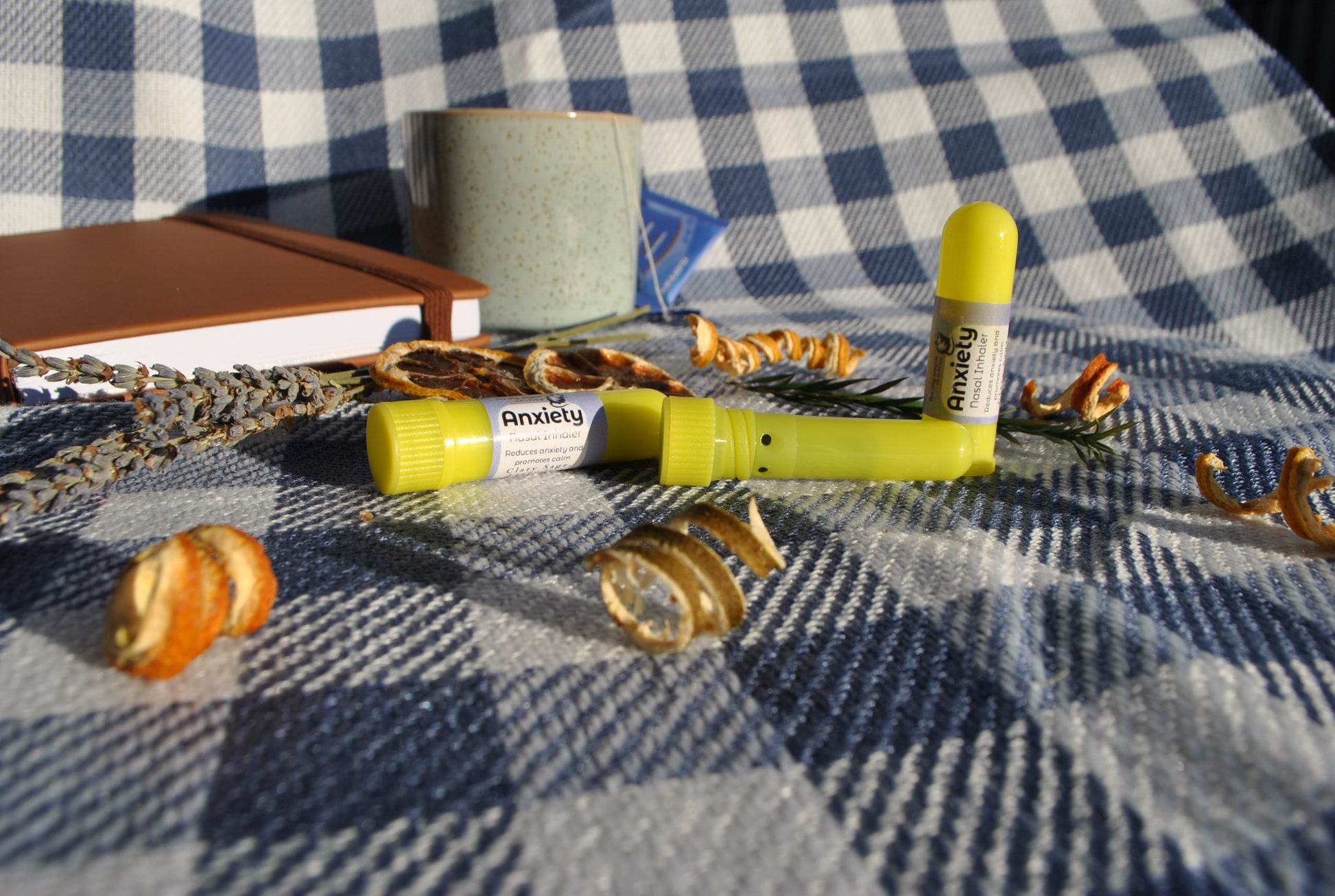 Anxiety Inhaler tube, natural essential oil aromatherapy for calm and relaxation Two yellow sticks on a checkered fabric background lid off