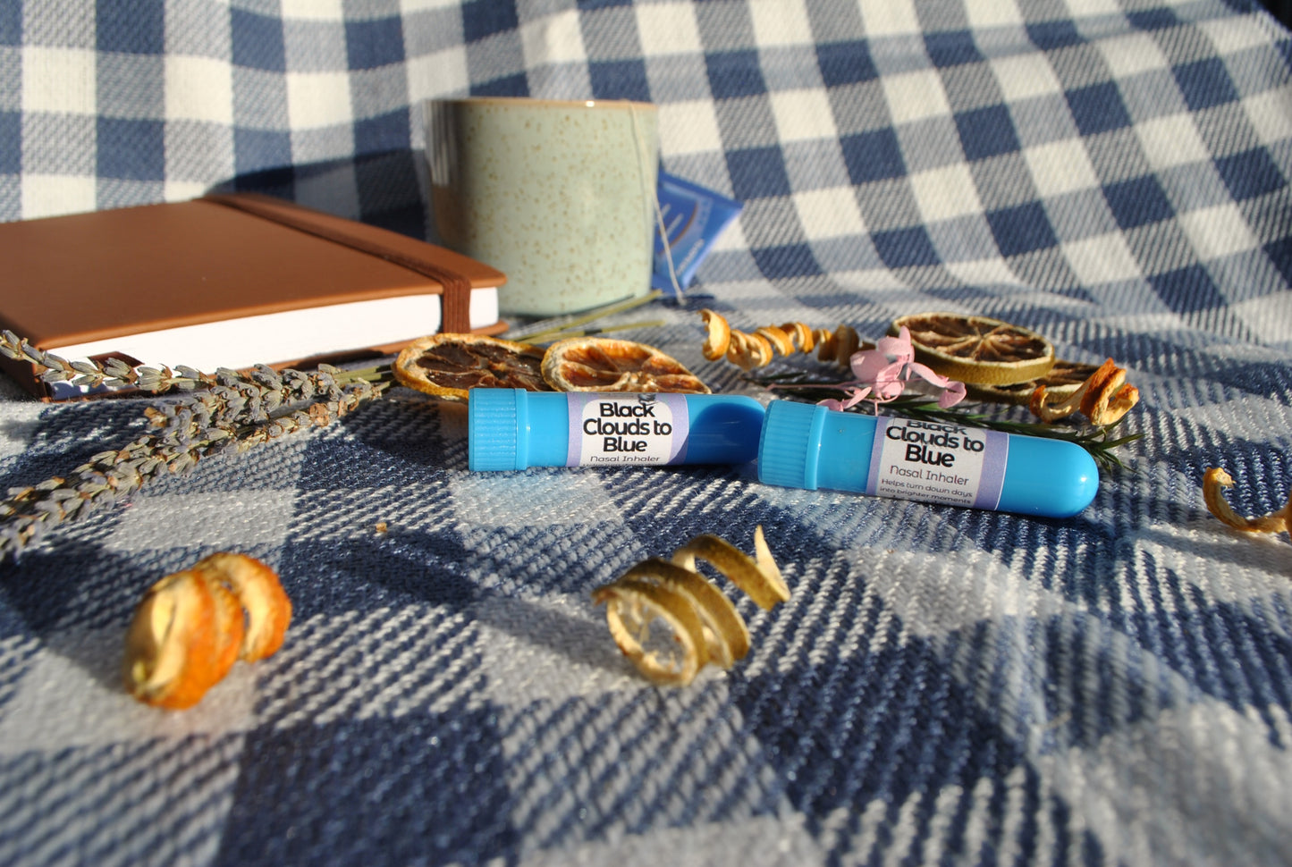 Black Clouds Inhaler tube, natural essential oil aromatherapy for low mood support on a checkered fabric background