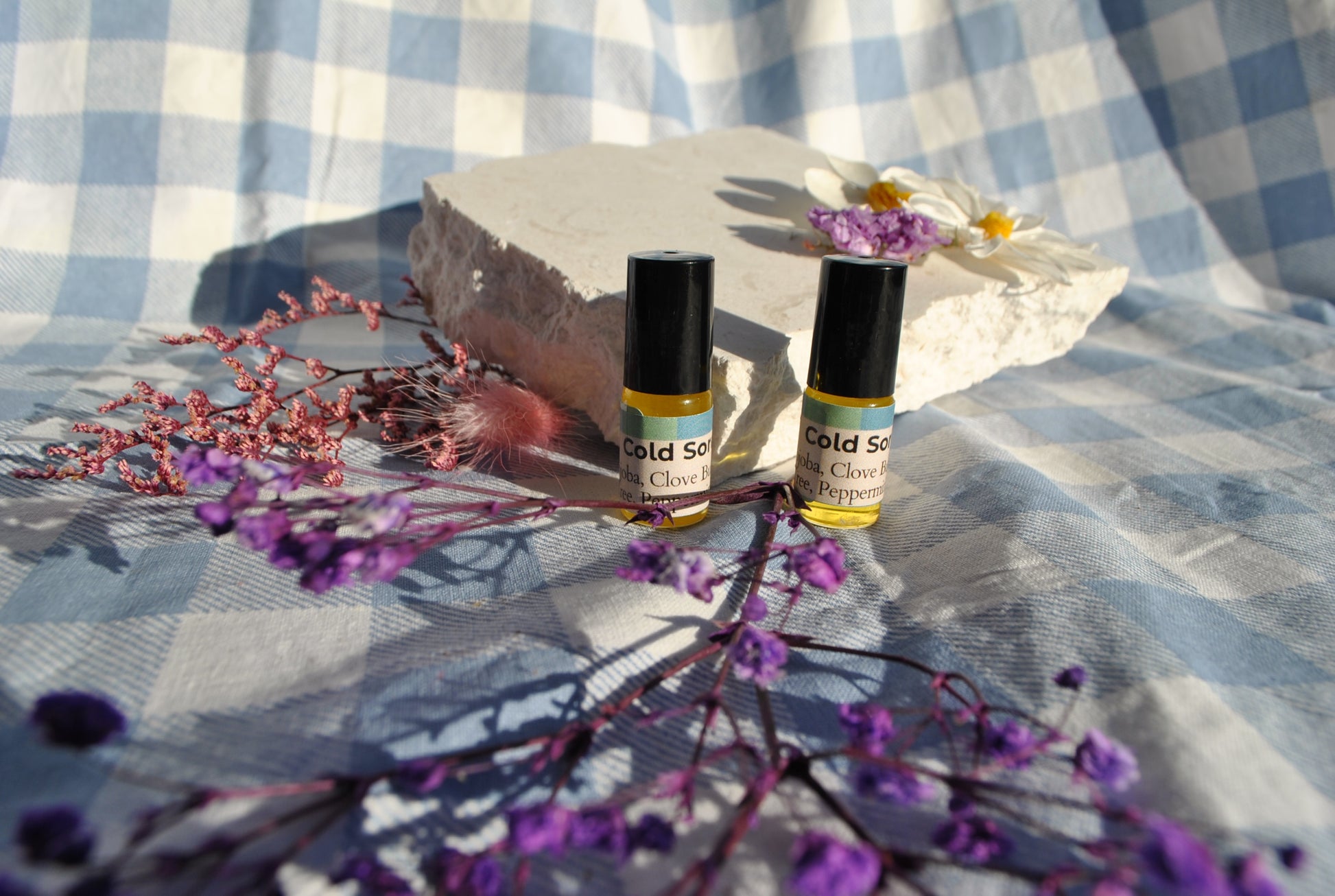 Cold Sore Relief balm jar, natural soothing balm for cold sores on a checkered fabric background with flowers.