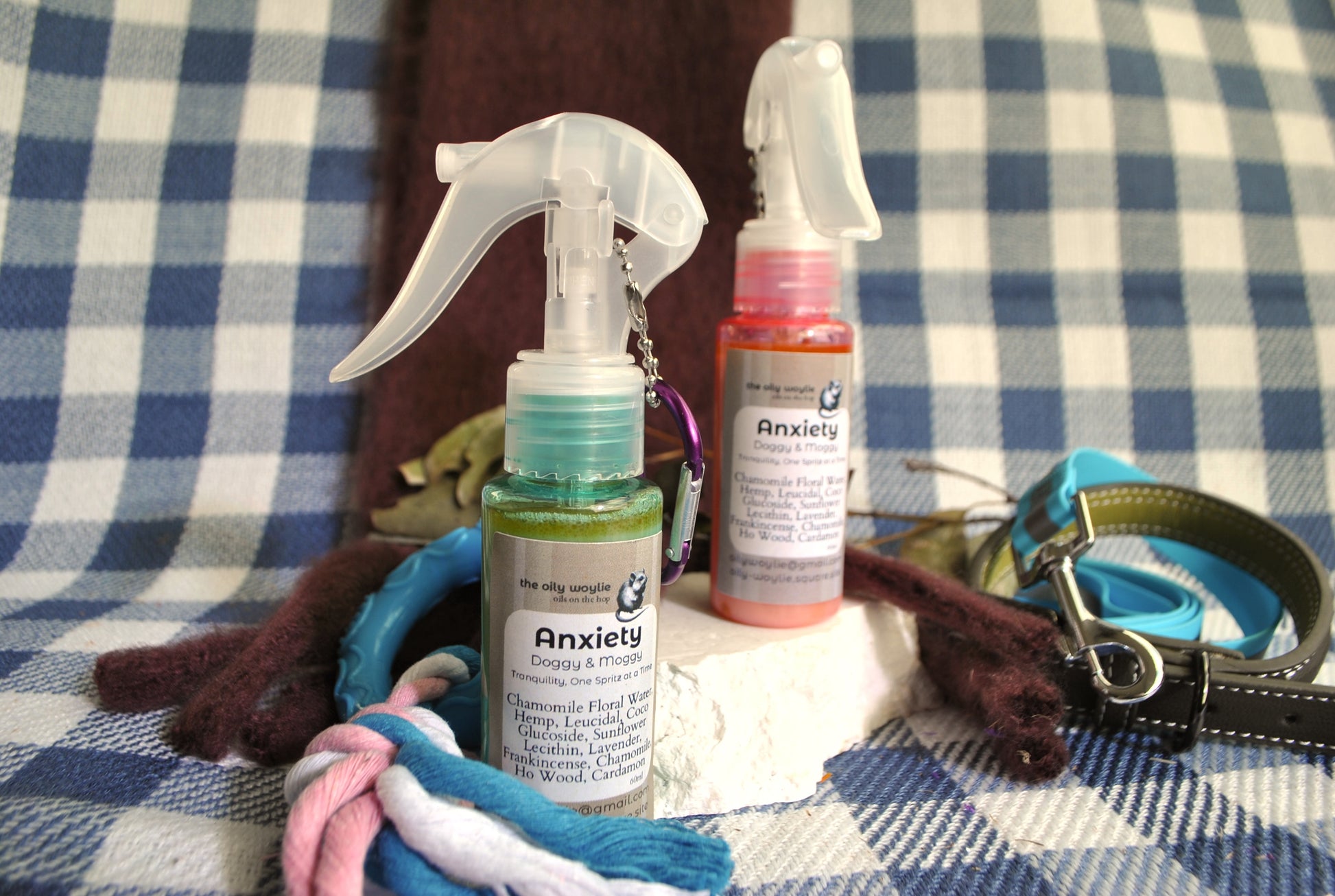 Doggy & Moggy Anxiety Blend natural spray for calming anxious pets on blue checkered cloth with dog accessories