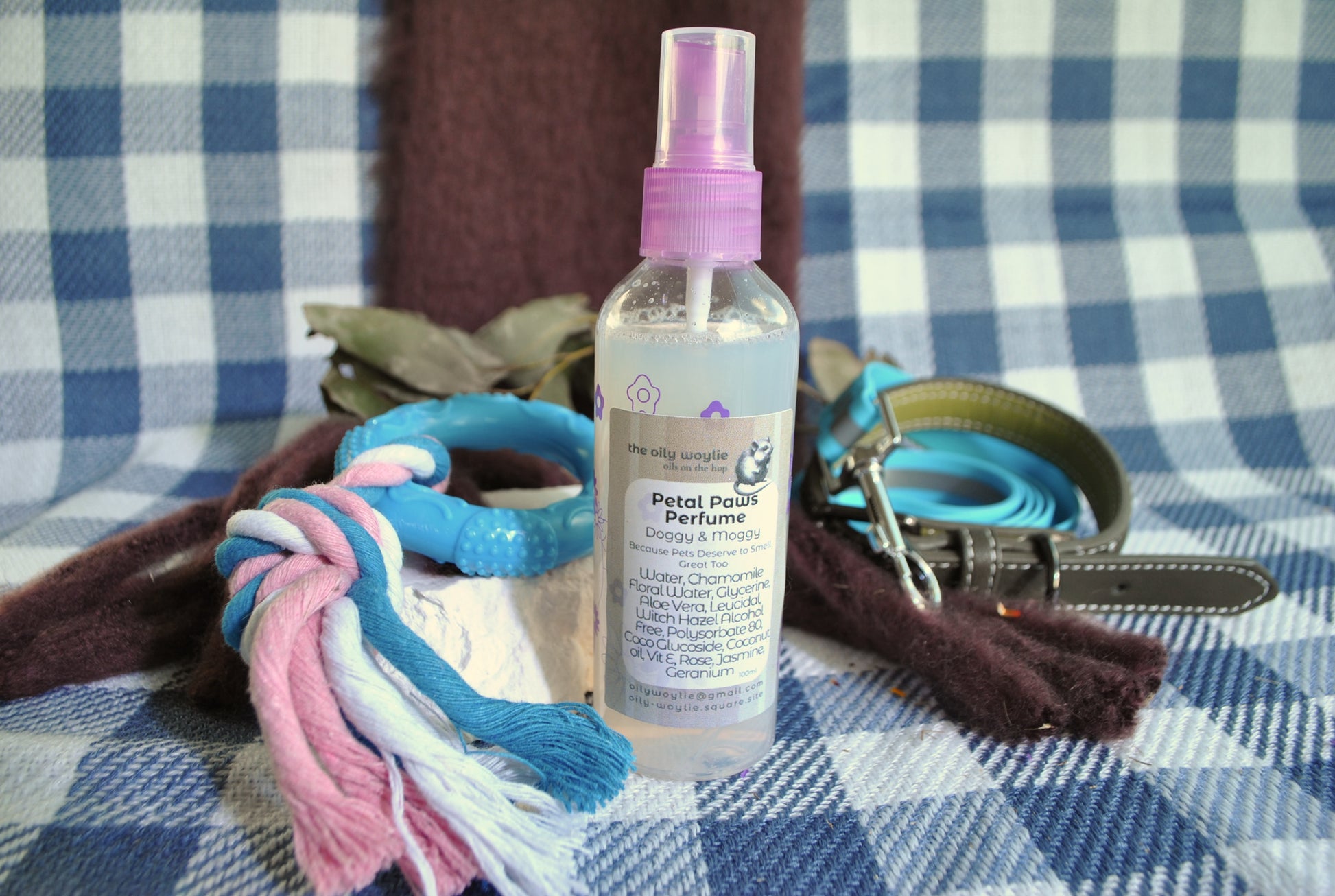 Doggy Perfume Petal Paws, natural floral spray to keep dogs smelling fresh on a checkered fabric background