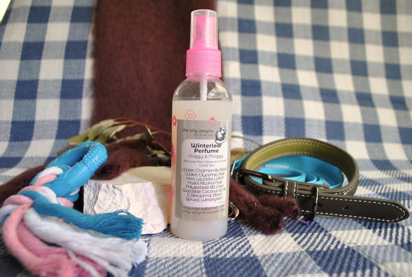 Doggy Perfume Winterleaf spray bottle, natural deodorising spray for dogs on a checkered background
