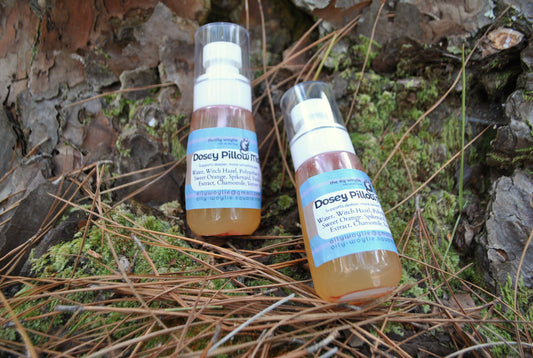 Dosey Pillow Mist spray bottle, natural essential oil mist to support relaxation and sleep on a natural background with leaves and twigs.