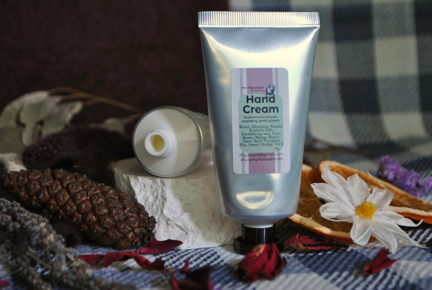 Hand Cream tube, natural moisturising cream for soft and nourished hands on a checkered fabric background with decorative elements