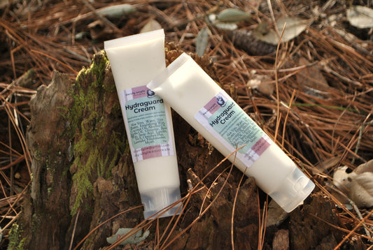 Hydraguard Cream tube, natural moisturising cream for dry skin protection on a natural background with leaves and wood.