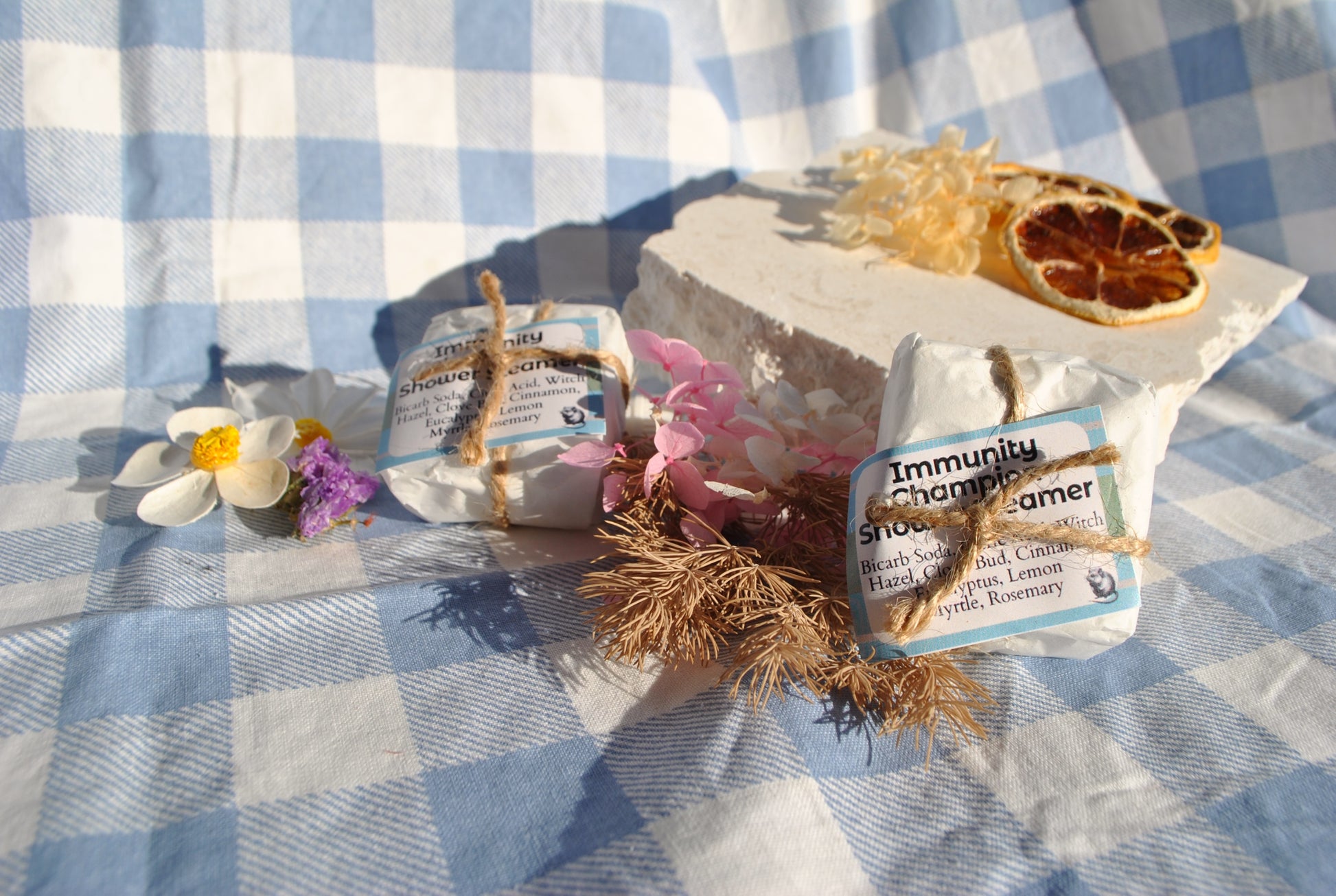 Immunity Shower Steamers tablets, natural essential oil steamers to support wellness and immunity on a checkered blue and white background