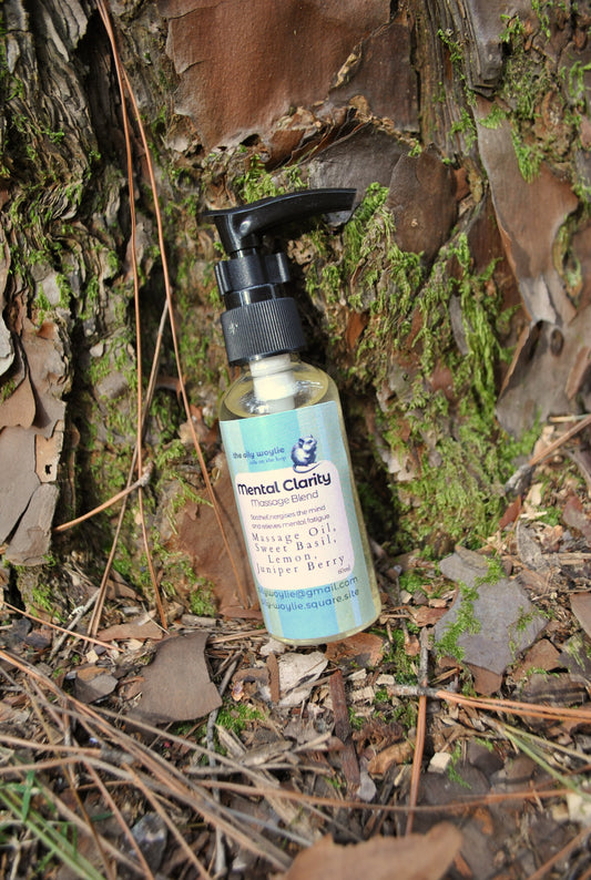 Mental Clarity Massage essential oil blend bottle, natural support for focus and concentration on a natural background with moss and leaves.