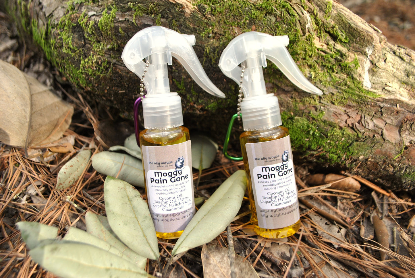 Moggy Pain Gone spray bottle, natural relief spray for cats with sore muscles and joints on a natural background with leaves and wood.