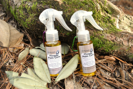 Moggy Pain Gone spray bottle, natural relief spray for cats with sore muscles and joints on a natural background with leaves and wood.