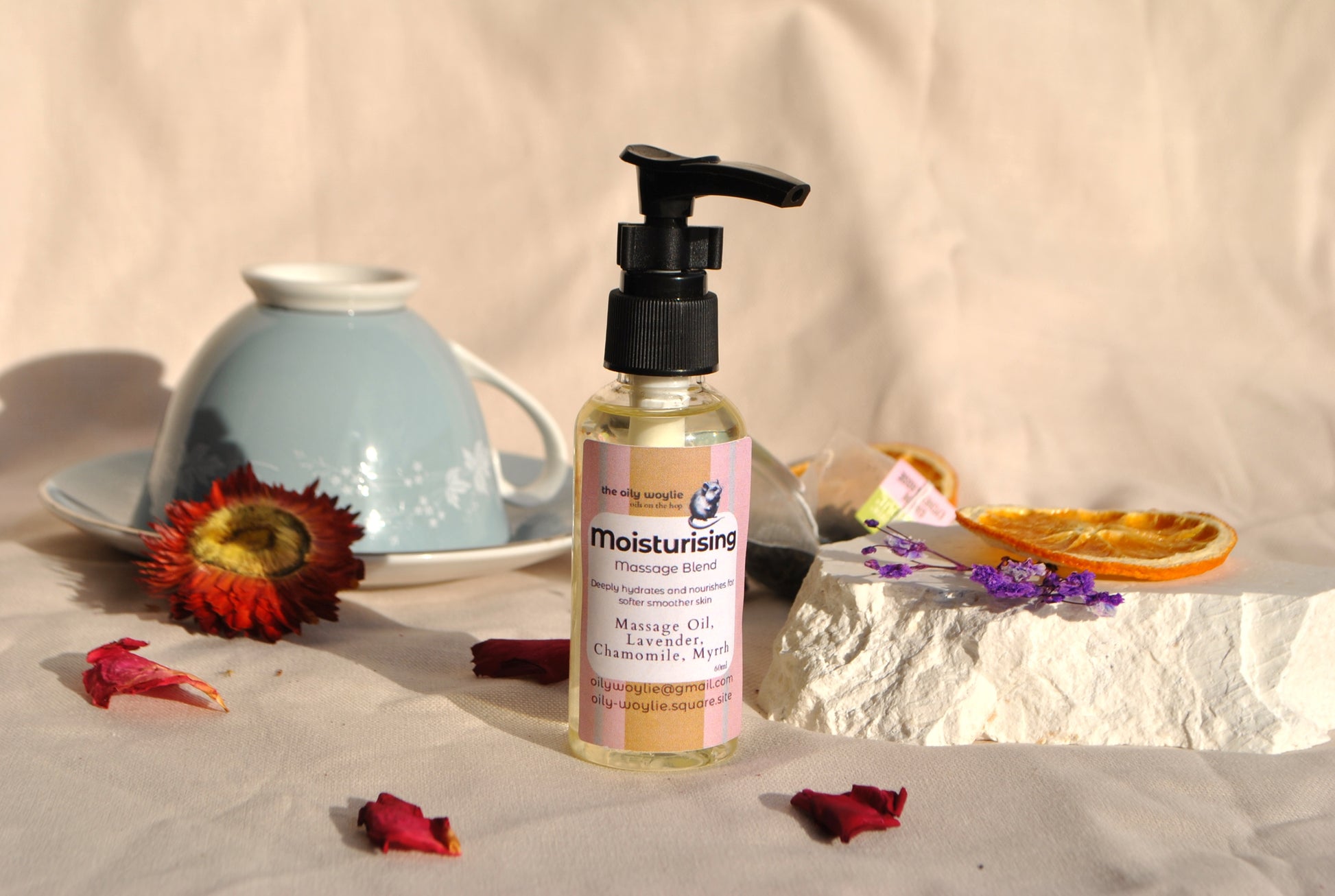 Moisturising Massage oil blend bottle, natural hydrating massage oil with a decorative setting on a beige surface