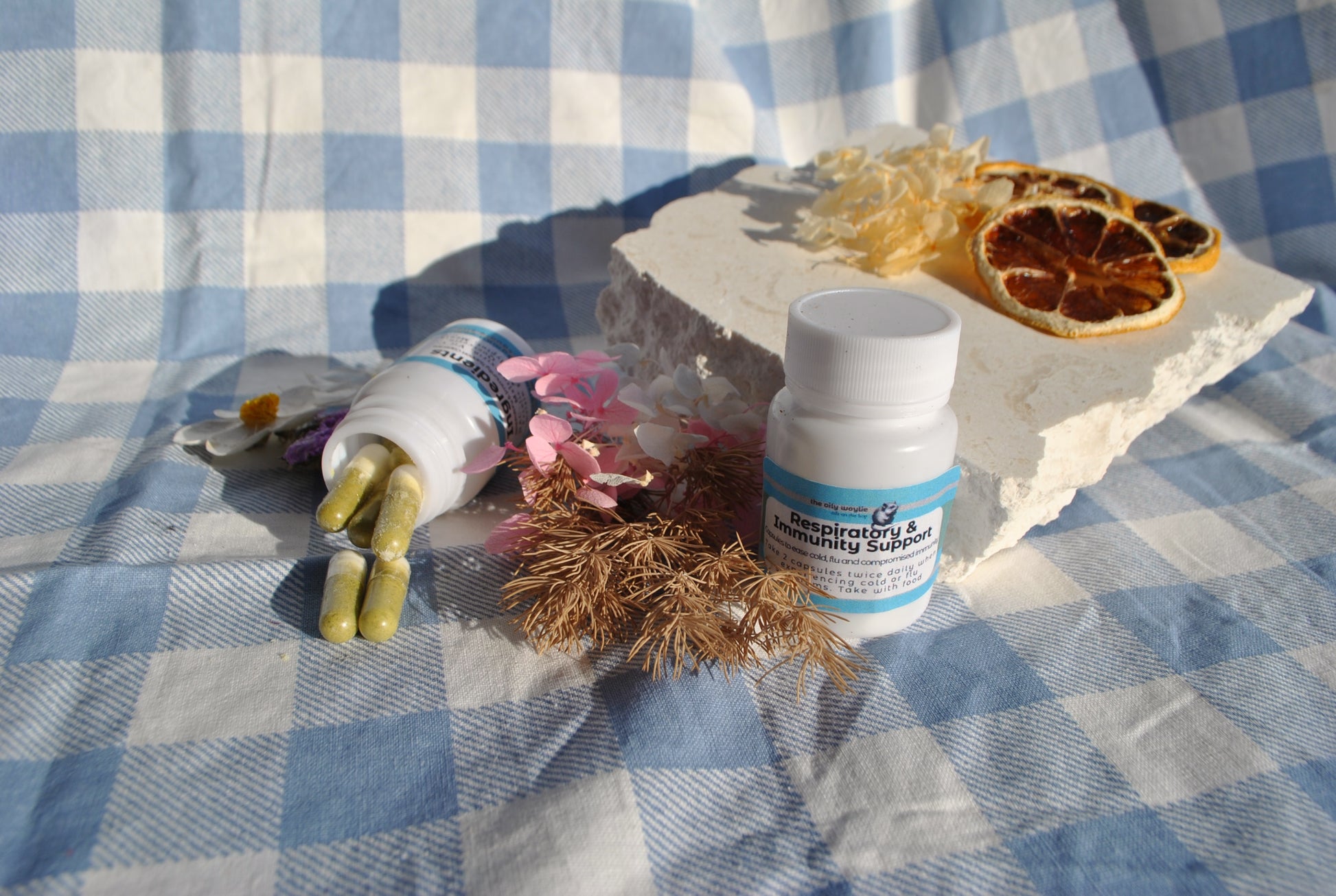 Respiratory & Immune Support Capsules bottle, natural supplement to support breathing and immunity on a checkered tablecloth with decorative items.