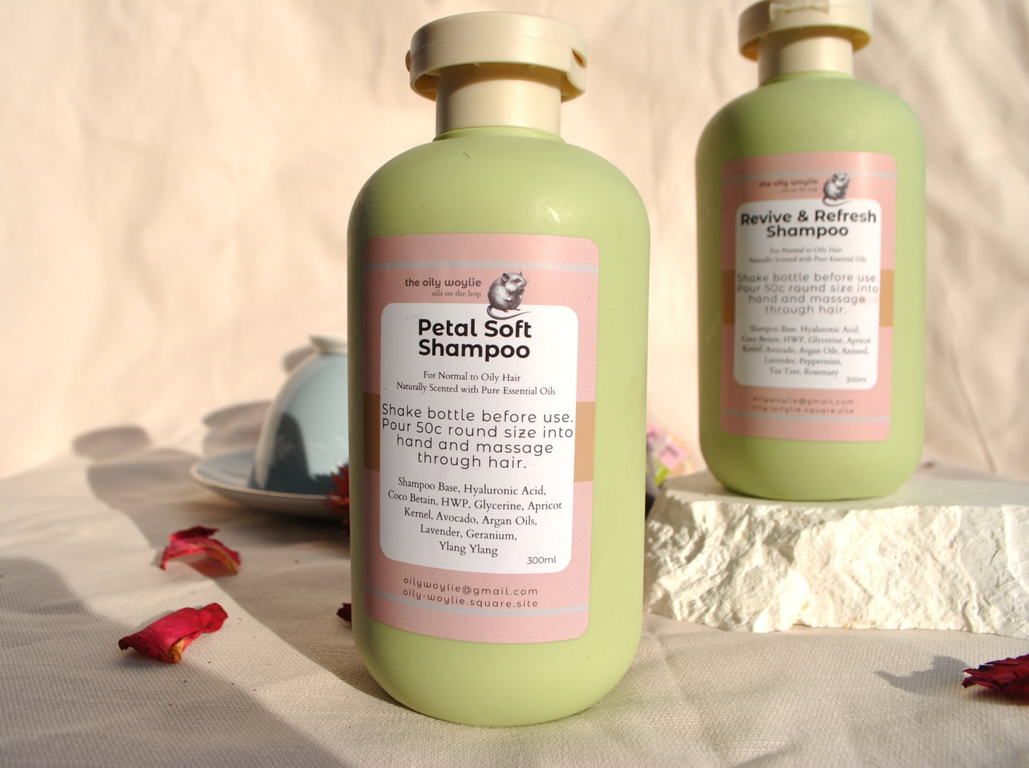 Revive & Refresh and Petal Soft natural shampoo bottles side by side, eco-friendly hair care on a textured surface with flowers and a bowl in the background.