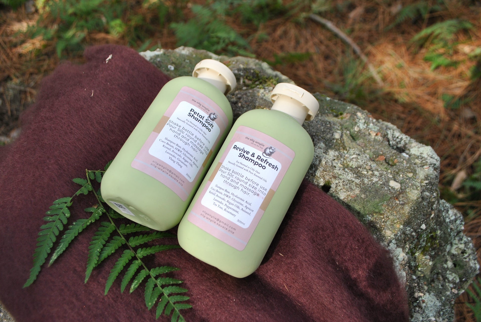 Revive & Refresh and Petal Soft natural shampoo bottles side by side, eco-friendly hair care on a brown fabric background