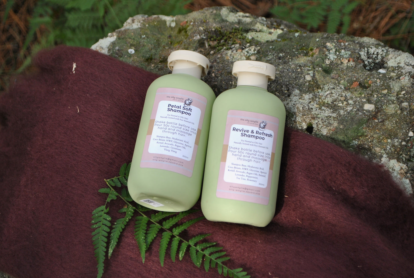 Revive & Refresh and Petal Soft natural shampoo bottles side by side, eco-friendly hair care on a textured surface with fern leaves.
