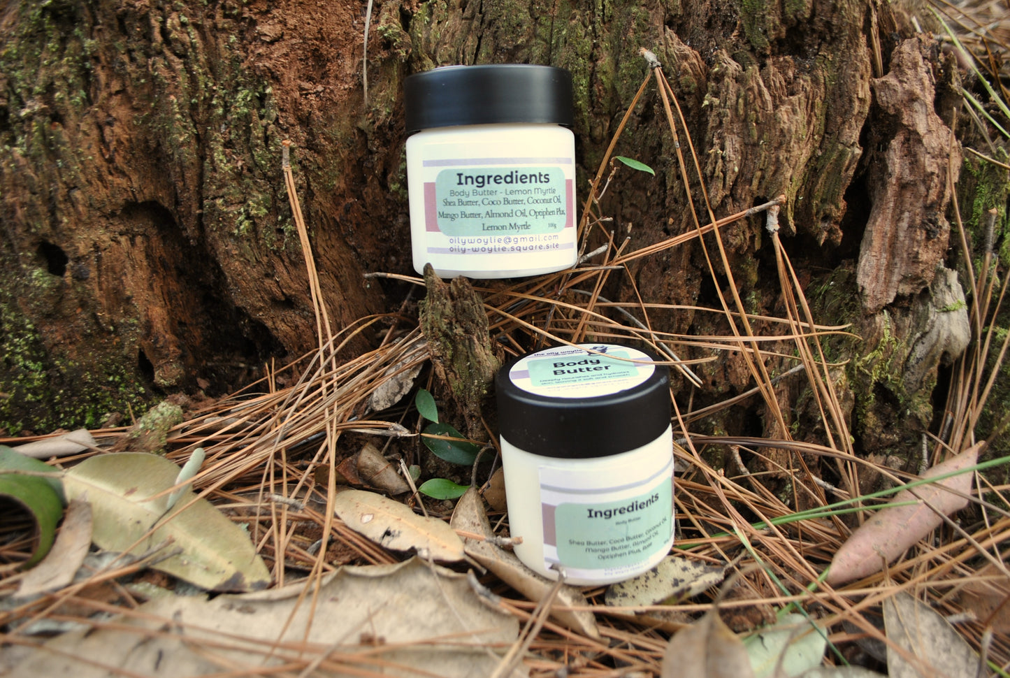 Rose and Lemon Myrtle Body Butter jars side by side, natural moisturising body creams on a natural background with leaves and wood.